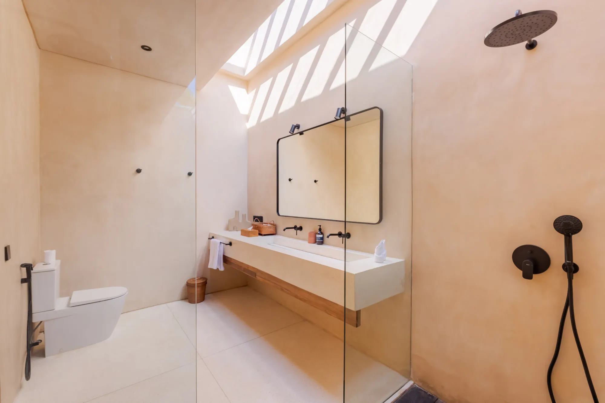Minimalist bathroom featuring frameless shower and stone details