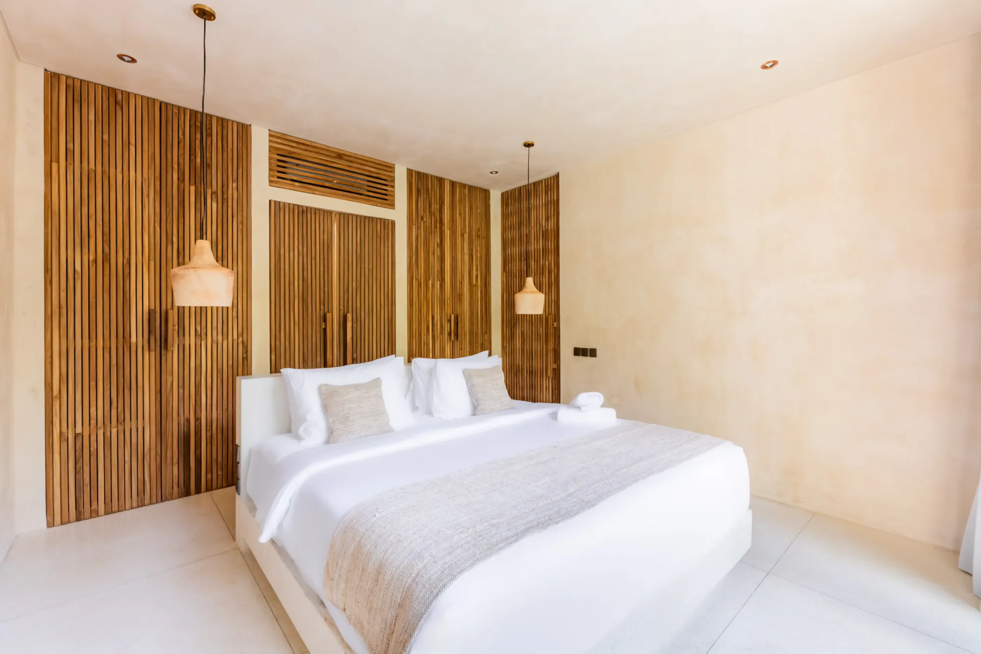 Contemporary bedroom with wooden accent wall and arched glass doors