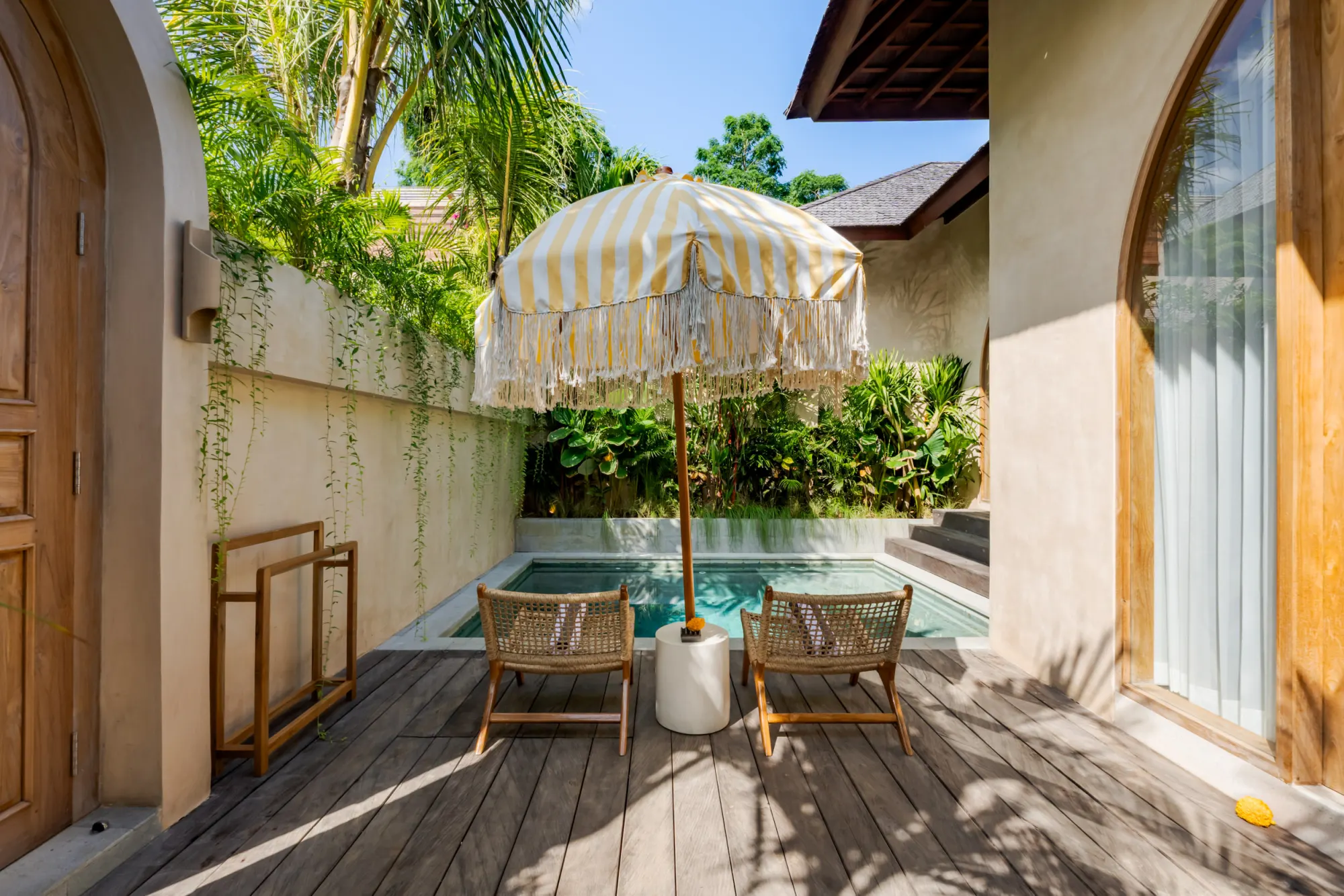 Private pool surrounded by tropical plants and modern architecture