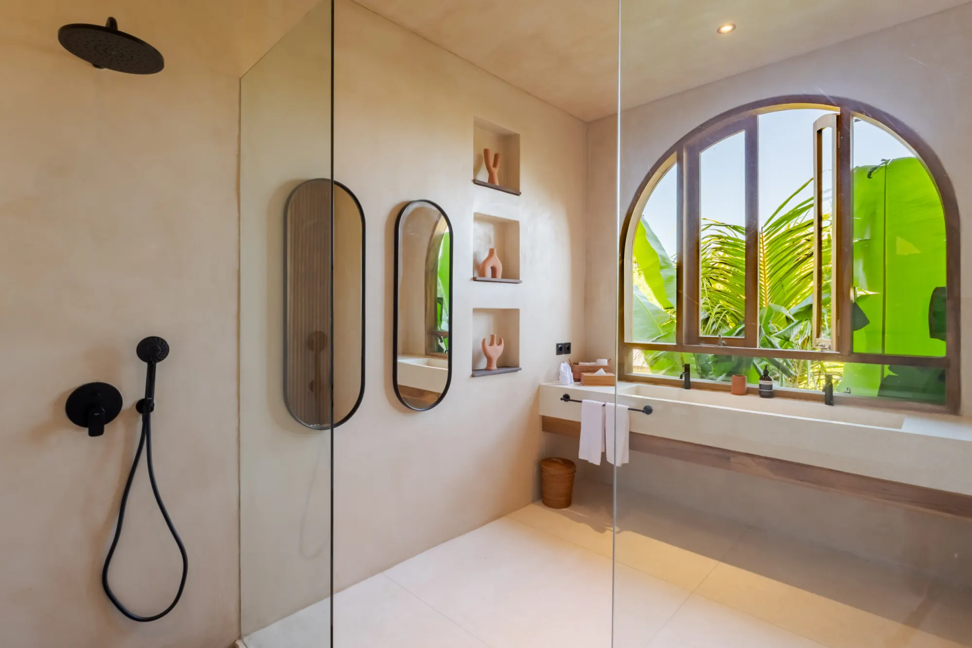 Modern bathroom with arched mirror and outdoor plant views
