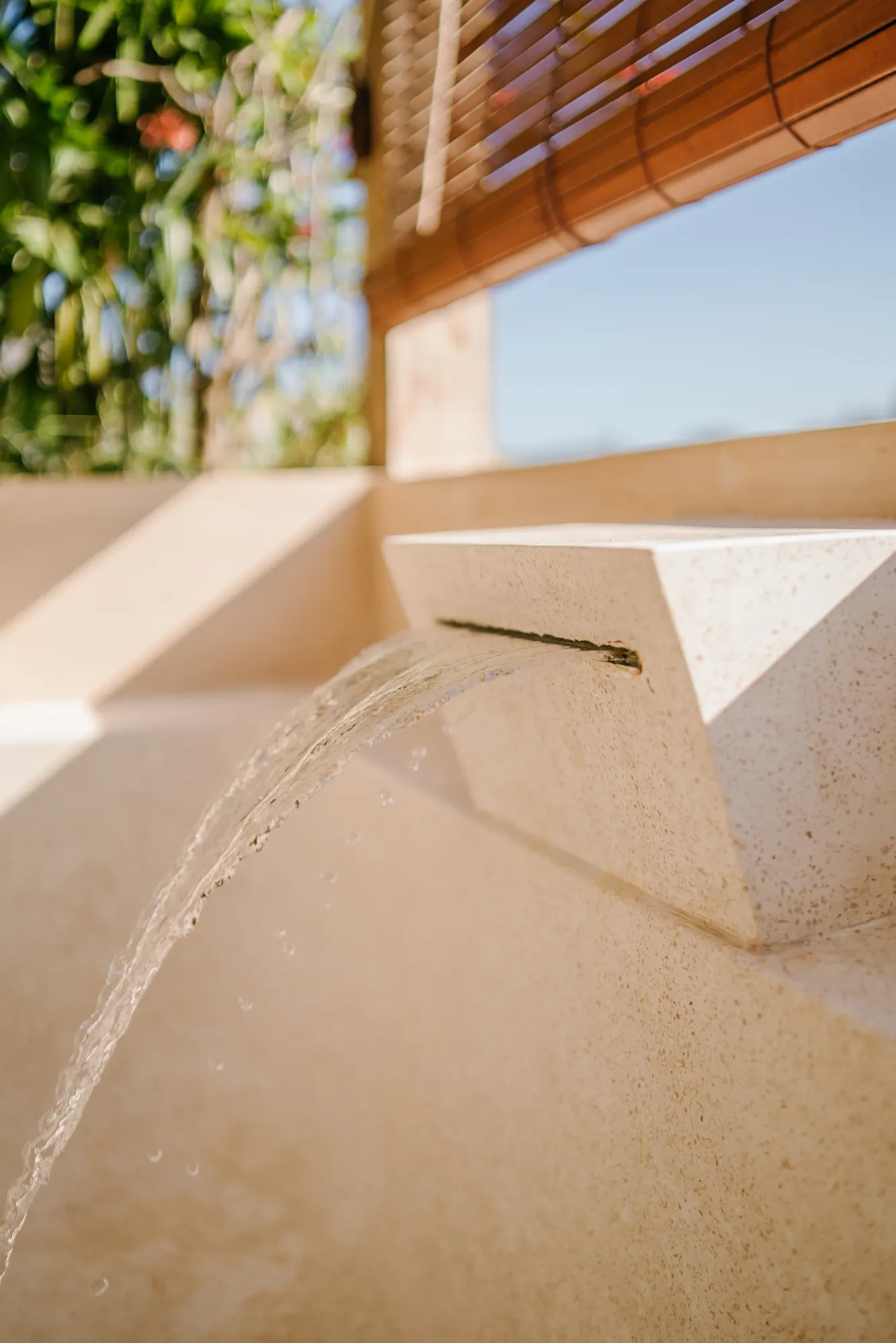 Outdoor stone spa basin with serene garden water feature