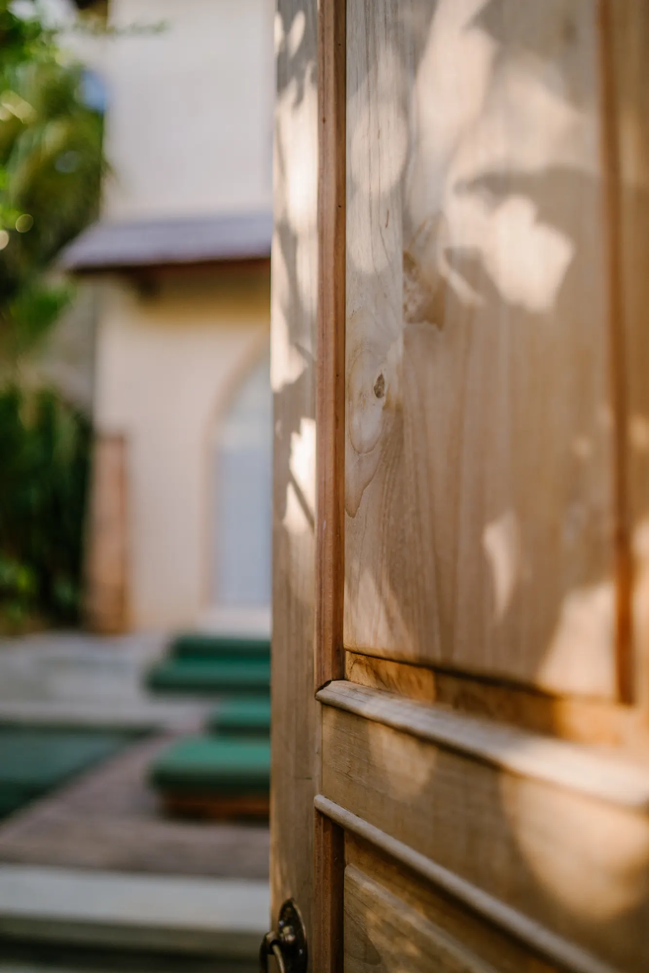 Wooden gate detail with garden backdrop and tropical foliage visible