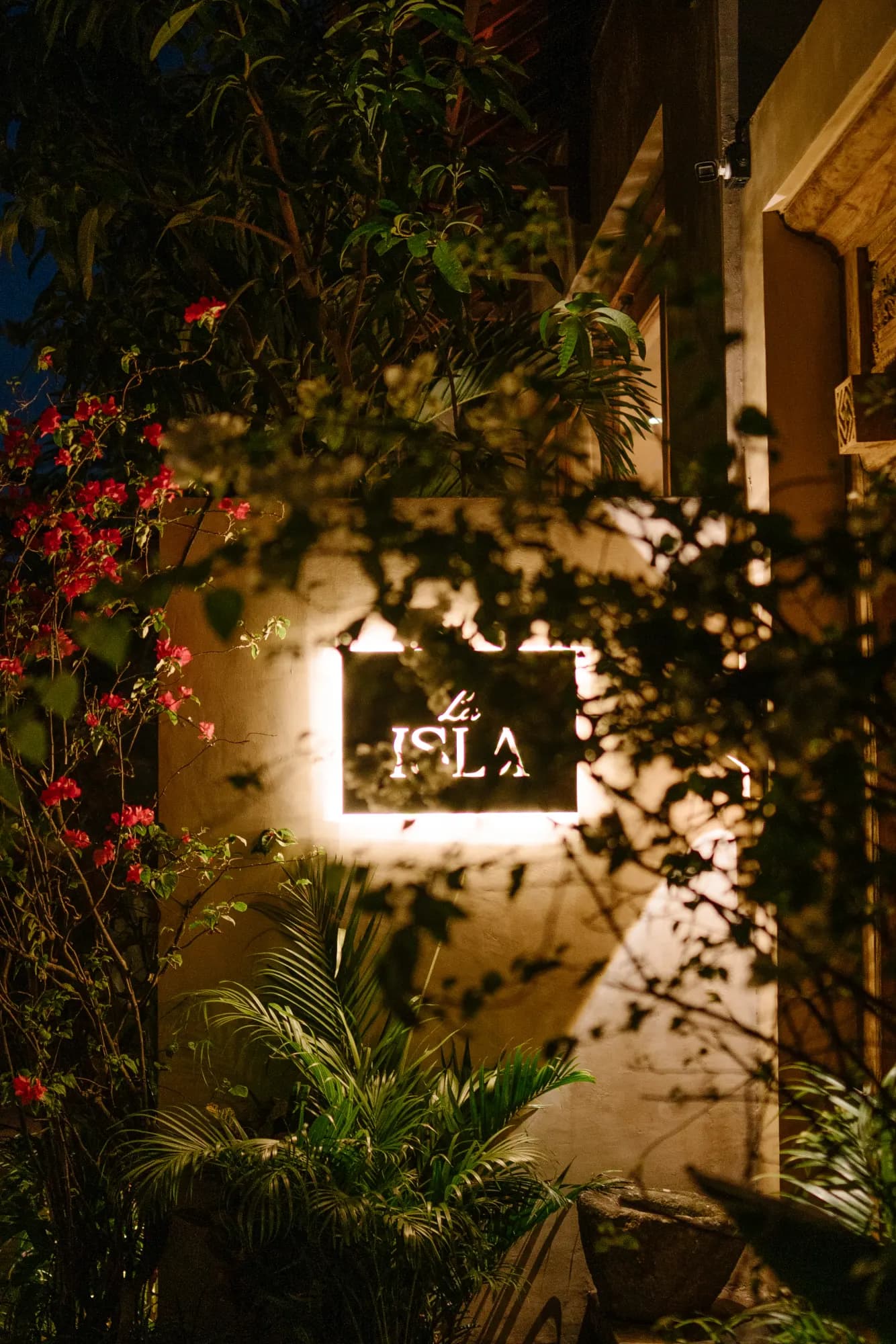 Nighttime entry courtyard with "La ISLA" signage lit