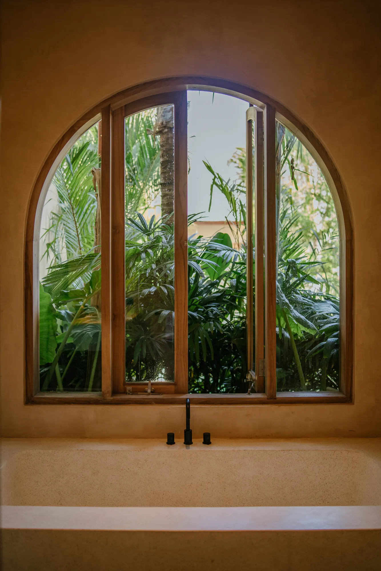 Arched window overlooking tropical garden