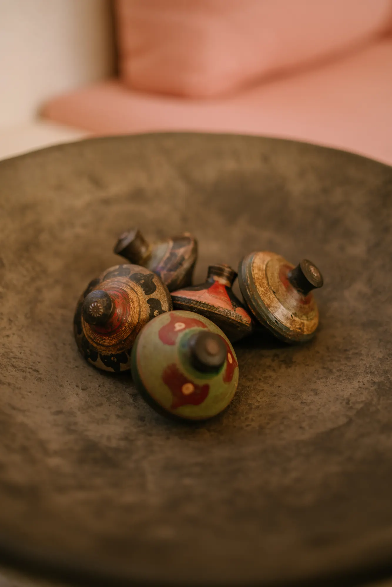 Vintage decorative knobs in shallow bowl on marble surface