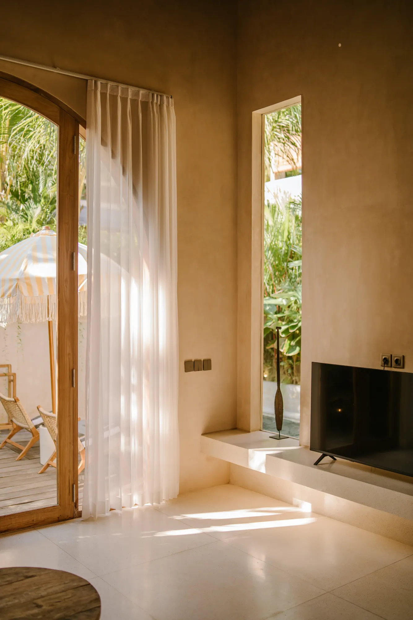 Light-filled living area with glass doors to tropical garden