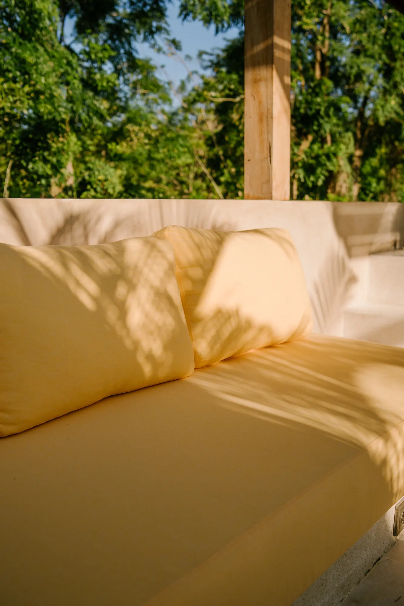 Bedroom with yellow pillows and sunset view through window