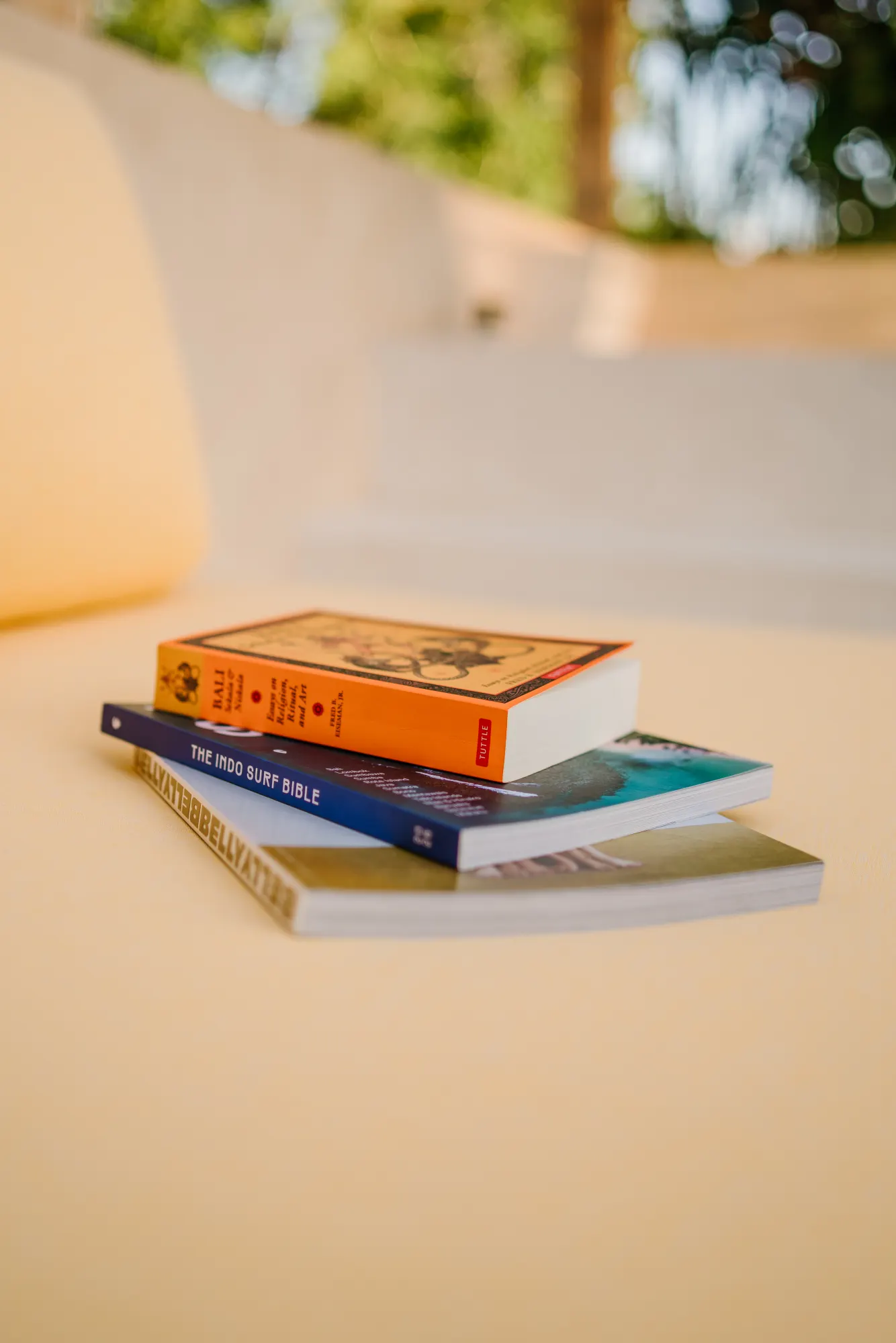 Stack of travel guides and books by the pool