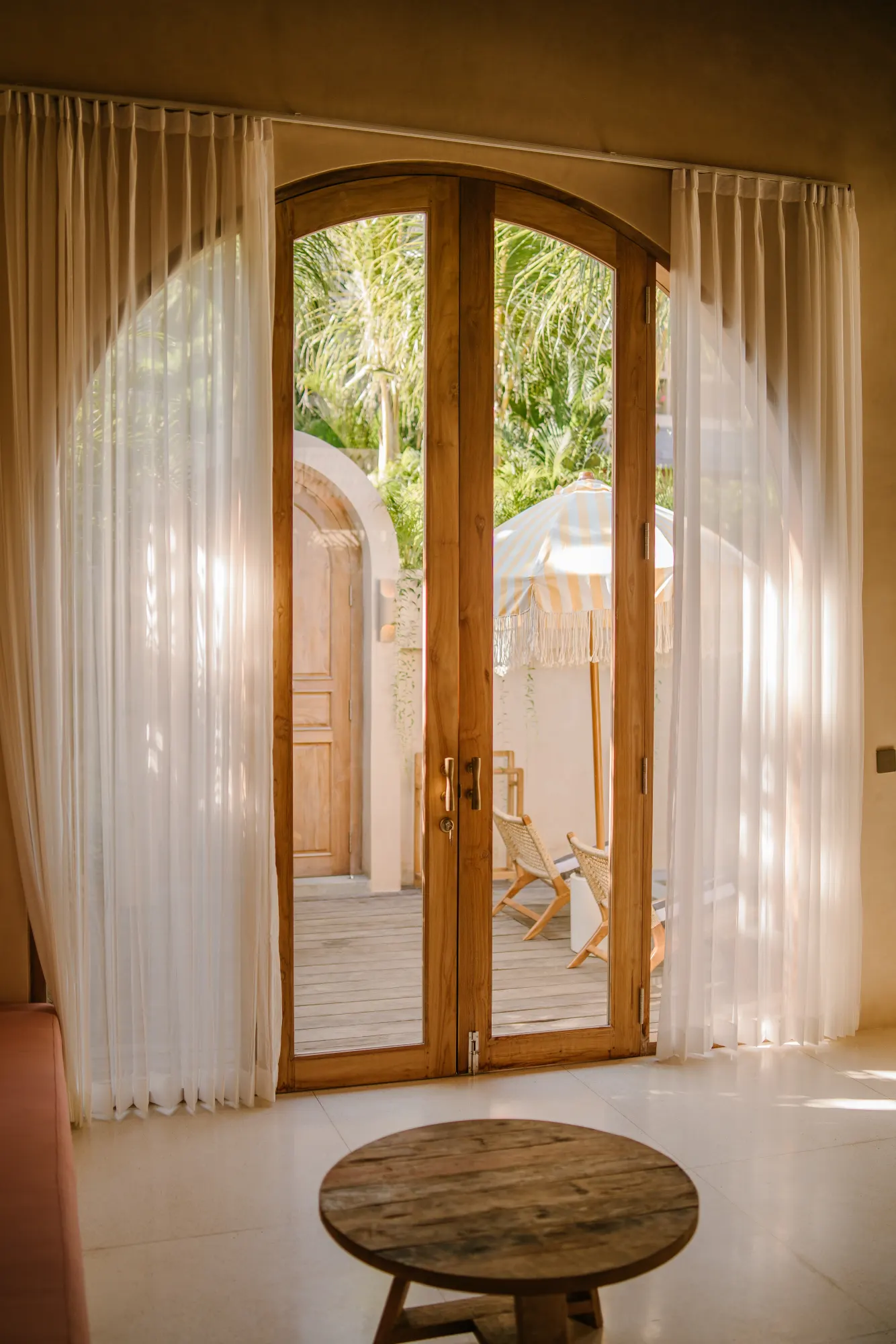 Sheer curtains framing glass doors opening to terrace