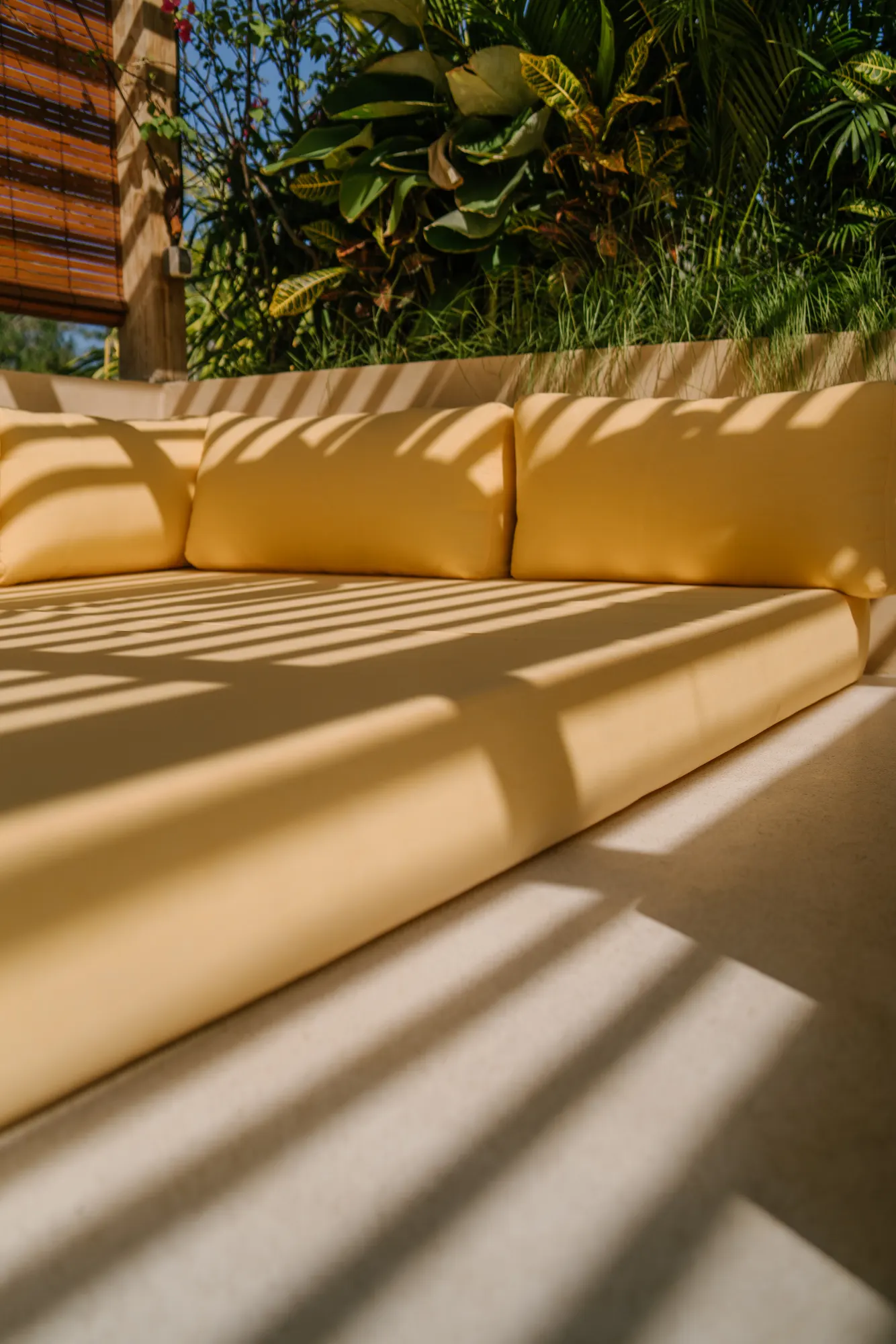 Sun-soaked terrace seating with plants and shadows